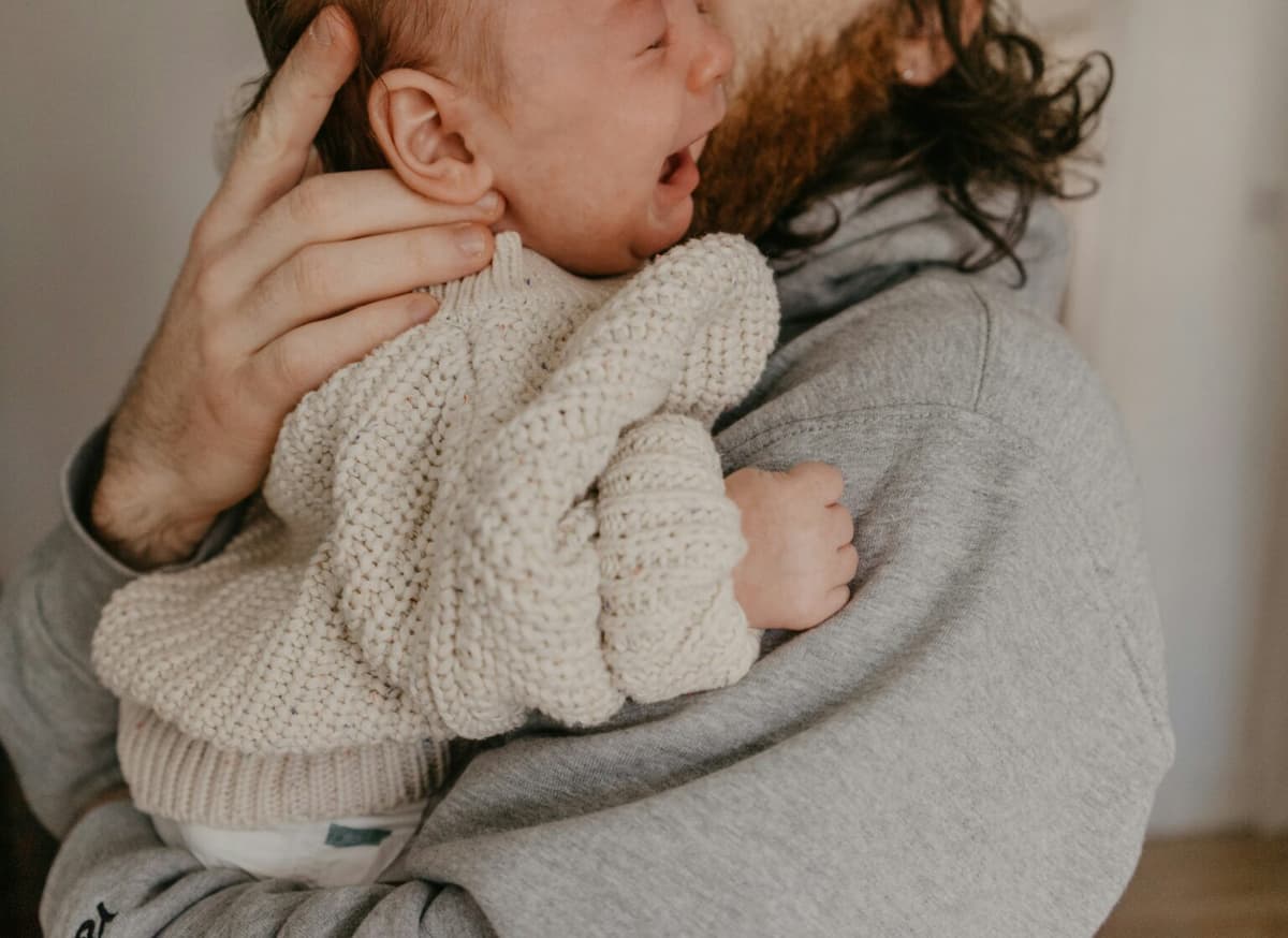 A parent comforting a crying baby